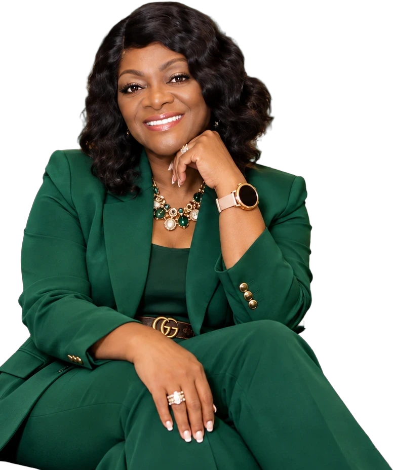 Apostle Dr. Mary Battle-Lewis smiling in an emerald suit with emerald and pearl jewelry